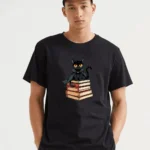 A Mysterious Black Cat Guards Its Literary Secrets Perched Atop A Stack Of Enchanting Stories T-Shirt
